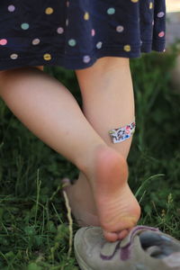 Low section of woman standing on field