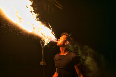 Man blowing fire at night