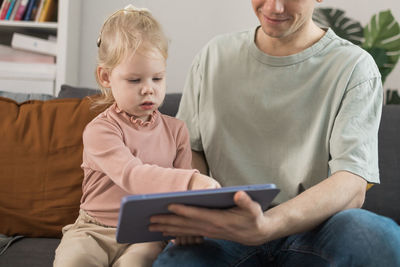 Young woman using phone while sitting at home