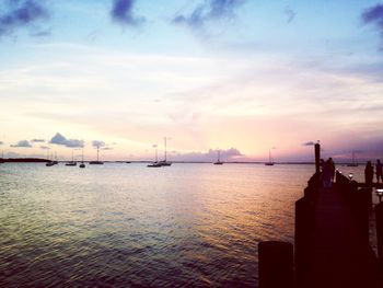 Boats in sea at sunset