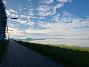 Footpath by sea against sky