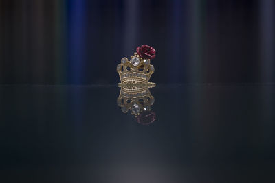 Close-up of ornamental king crown with rose on top