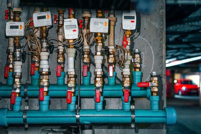 Close-up of pipes with valves and meters on city street