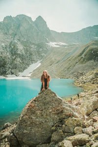 Woman standing on rock by mountain