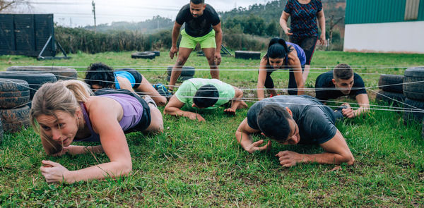 Friends crawling under strings on land