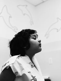 Close-up of girl looking away against wall