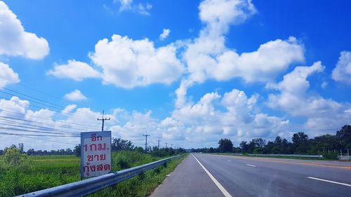 Road by landscape against blue sky