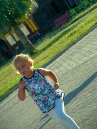 Portrait of happy girl playing on grass