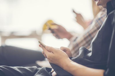 Midsection of man using mobile phone