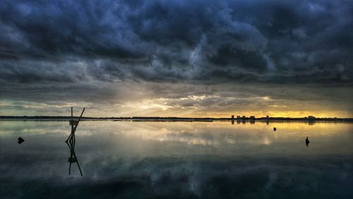 Storm clouds reflecting in sea during sunset