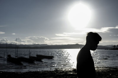 Side view of silhouette man against sea against sky