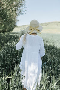 Rear view of a woman standing on field