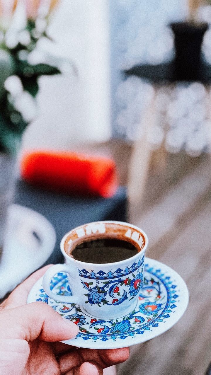 CLOSE-UP OF HAND HOLDING COFFEE