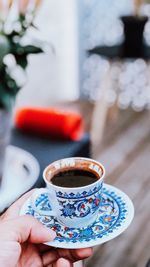 Close-up of hand holding coffee cup