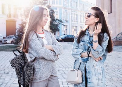 Friends talking while standing on street