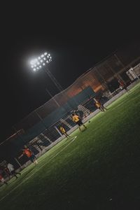 Low angle view of soccer field against sky at night