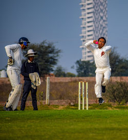 Full length of boy standing on field against sky