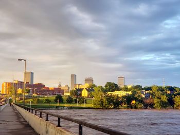 River by buildings in city against sky