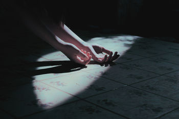 Cropped hands of woman on tiled floor