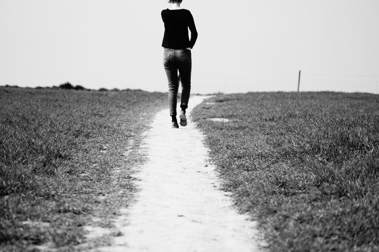 the way forward, walking, rear view, lifestyles, clear sky, field, full length, landscape, leisure activity, men, standing, sky, tranquility, copy space, road, dirt road, tranquil scene, person