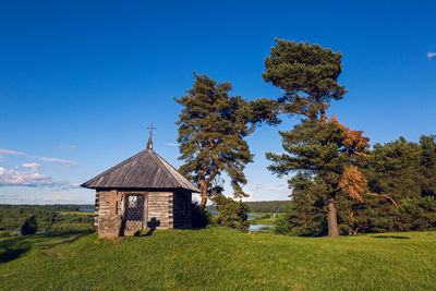  wooden chapel and stone cross on the top of savkin hill, pushkinskiye gory reserve, russia