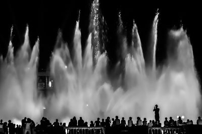 People against fountain at night