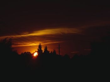 Silhouette trees against sky at sunset