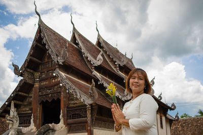 Portrait of woman against temple against sky