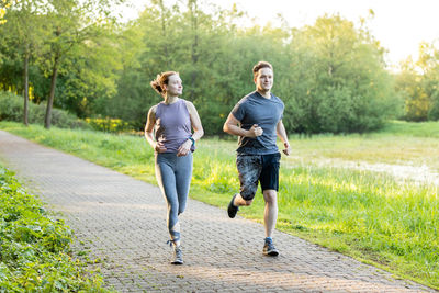 Full length of man running on footpath