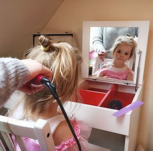 Cropped hand of mother drying daughter hair