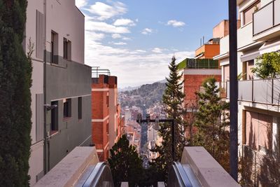 Residential buildings by street against sky