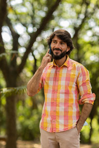 Young man at park on a beautiful sunny day with mobile phone.  working  leisure. green and nature 