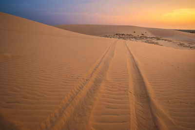 Scenic view of desert against sky during sunset