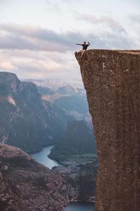 Man sitting at edge of cliff at preikestolen, norway