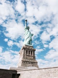 Low angle view of statue of liberty  against cloudy sky