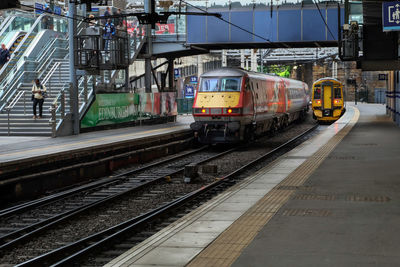 Train on railroad tracks in city against sky