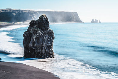 Scenic view of rocks in sea against sky