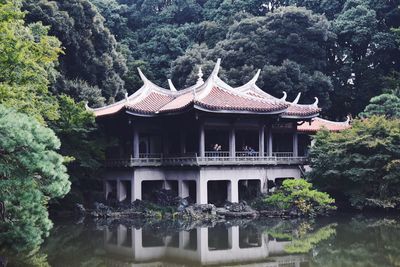 Building by lake against trees