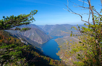 Scenic view of lake and mountains against blue sky