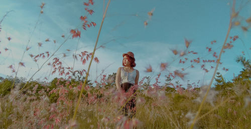 Woman standing on field against sky