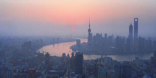 Aerial view of buildings in city during sunset