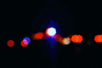 Defocused lights against sky at night