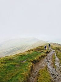 People walking on road against sky