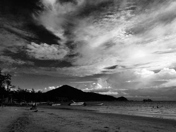 Scenic view of beach against cloudy sky