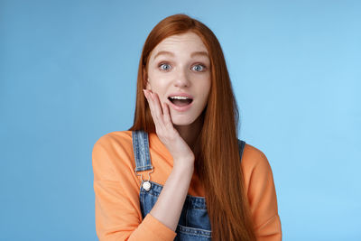 Portrait of a beautiful young woman against blue background