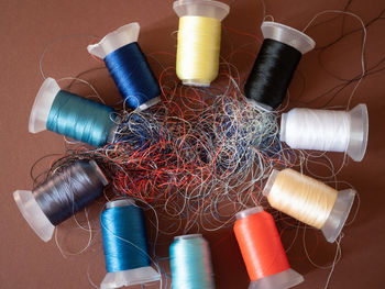 High angle view of multi colored spools on table