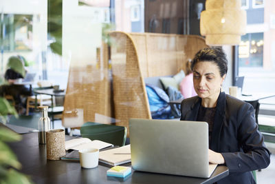 Businesswoman using digital tablet in cafe