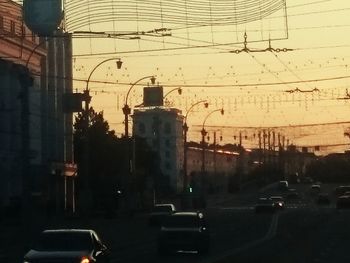 Cars on street in city during sunset