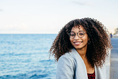 Portrait of smiling woman against sea against sky