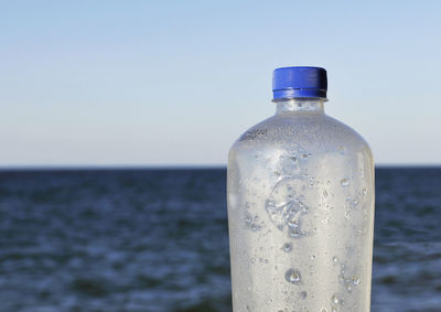 Close-up of water bottle against clear sky